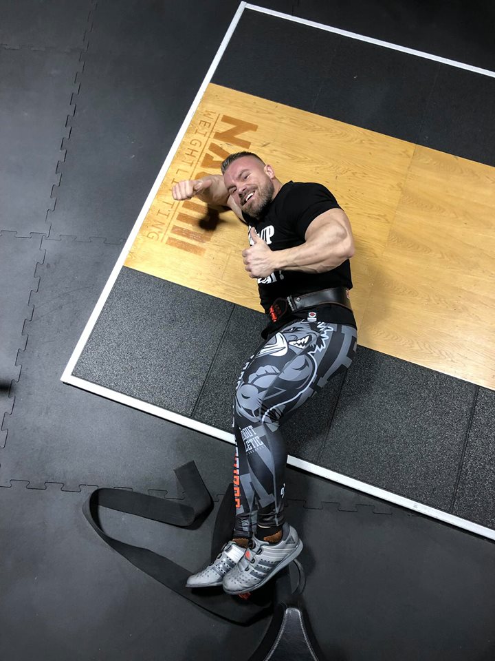 Kulturysta w spodniach na siłownię odpoczywa po treningu nóg